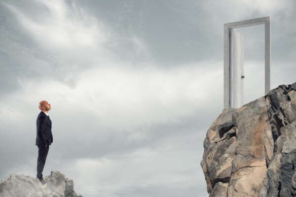 Businessman thinks about how to get to a door. concept of ambition in business